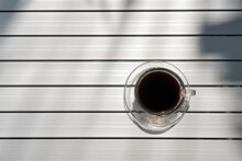 Top View Of Black Coffee Cup On The Stainless Steel Table With The Shade Of Tree's Shadow