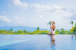 © siraphol - Portrait beautiful young asian woman enjoy around outdoor swimming pool with sea view