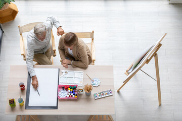 Wall Mural - Ariel view couple artist meeting and brainstorming for work on the table