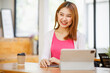 © David - Portrait of a beautiful young and intelligent-looking Japanese Asian woman student wearing a white shirt and pink tracker smiling as she works on her laptop in a university classroom.