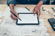 © Charnchai saeheng - Architect engineer use tablet to read drawing design. House planning design and construction concept.