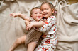 © Татевик Багдасарян - cheerful sister and younger brother hugging each other and lying on a blanket, laughing children, lifestyle