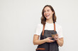 © Martin Villadsen - Portrait of beautiful young barista woman looking left and smiling or laughing, while holding a to-go coffee in hand. Isolated on white background.