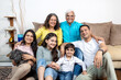 © Photographielove - indian family sitting on sofa at home