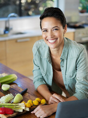 Canvas Print - Eating healthy doesnt have to be bland. Portrait of a smiling young woman using a digital tablet while preparing a meal in her kitchen.