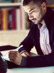 Aufkleber - Getting down to the task at hand. Shot of a focused young man working on a digital tablet in his home office in the early evening.