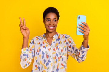 Portrait of friendly person take selfie recording video hand fingers show v-sign isolated on yellow color background