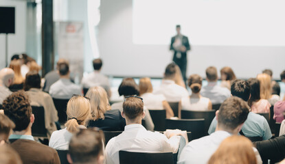 Business speaker giving a talk at business conference event.