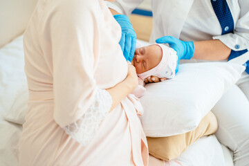 Breastfeeding advice concept. Female breastfeeding consultant supports young mother, help her comfort breastfeeding baby using pillow.