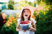 Cute European Girl Child Teenager With Big Bowl Of Raspberries, Daughter Helps Pick Berries In Garden, Eco-friendly Healthy Eating Natural Berries