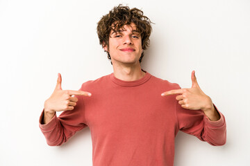 Young caucasian man isolated on white background person pointing by hand to a shirt copy space, proud and confident