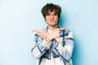 © Asier - Young caucasian man isolated on blue background points sideways, is trying to choose between two options.