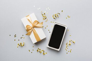 Wall Mural - Opened gift box with gold ribbon and smartphone on color background, top view. Blank open box packaging mockup , Template for your design - branding mockup