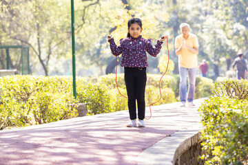 Wall Mural - Kids girl doing exercies with jump at park