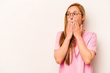 Young caucasian woman isolated on white background thoughtful looking to a copy space covering mouth with hand.