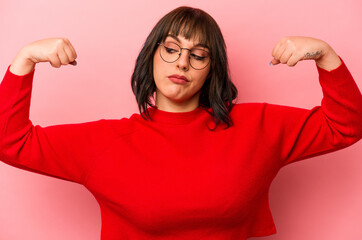 Young caucasian woman isolated on pink background showing strength gesture with arms, symbol of feminine power