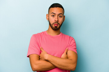 Young hispanic man isolated on blue background unhappy looking in camera with sarcastic expression.