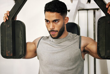 Sticker - Theres no day that doesnt demand a good workout. Shot of a young man working out with a chest press in a gym.