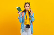 © Bangun Stock Photo - Portrait of pensive young Asian traveler holding boarding pass passport ticket and talking on smartphone isolated on yellow background. Passengers traveling on weekends. Air flight travel concept