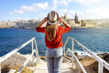 Holidays In Malta. Back View Of Beautiful Girl Enjoying View Of Valletta Cityscape With The Blue Water Of Mediterranean Sea.
