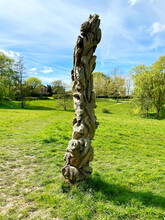 An Old Carved Tree Trunk Sculpture In A Park
