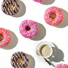 A Cup Of Coffee And A Variety Of Donuts On A White Background. Flat Lay Composition With Coffee And Donuts.