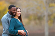© PheelingsMedia - Interracial couple with pregnant wife looking away