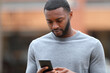 © PheelingsMedia - Man with black skin is using smart phone