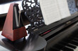 closeup of wooden metronome on an old black piano