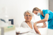 © PoppyPix - doctor making vaccination to senior woman patient medium closeup hospital vaccination concept . High quality photo