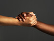 © Chanelle Malambo/peopleimages.com - Everyone needs a helping hand. Studio shot of two unrecognizable people holding hands against a grey background.