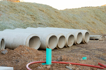 Sticker - Large concrete water pipes lying on a construction site on a field to build a drainage sewage system against flooding, copy space, selected focus