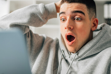 Poster - astonished young man looking at the computer