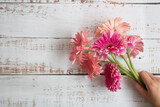 Fototapeta  - Ramo de flores color rosa sobre mesa blanca de madera