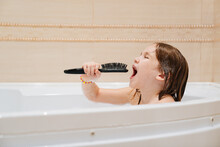 Cheerful Girl Washes, Plays And Sings Into Comb Like Microphone In Bathroom