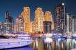 © Great Brut Here - Dubai Marina Port, UAE, United Arab Emirates - Jetty With Many Moored Yachts In Evening Night Illuminations. Night View Of Dubai Marina Towers.