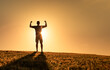 © kieferpix - Strong, fit, healthy young man silhouette flexing his arms up to the sunrise. will power, and strength concept.