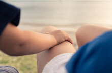 Parenting Trust, And Child Care. Childs Hand On Mothers Lap Sitting Together By The Sea. 