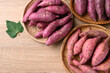 Various sweet potato in basket on wooden background, Table top view