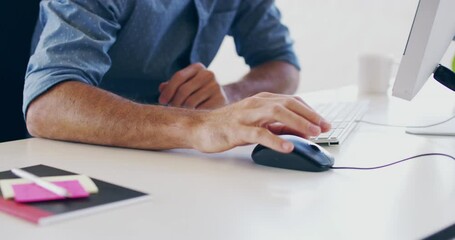 Getting down to business on the desktop. 4K closeup video footage of a man working on a computer in a modern office.