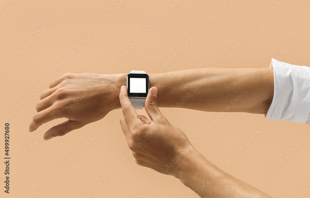 Male hands with modern smart wrist watch on color background