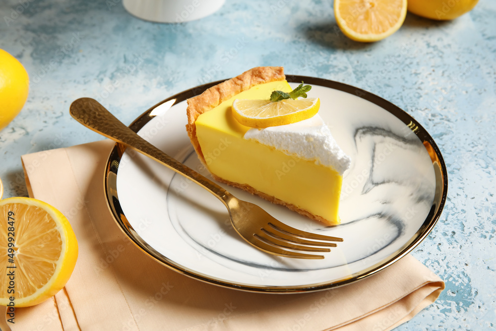 Plate with piece of tasty lemon pie on blue background