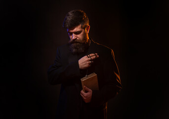 Praying hands priest portrait of male pastor. Man in suit with a Bible. Pastor or preacher praying, priest portrait of male pastor.