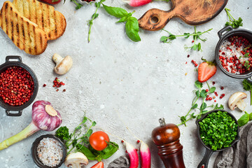 Table with vegetables, spices and condiments. Preparation for cooking. On a stone background. Top view.