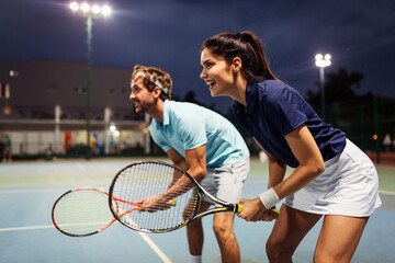 Wall Mural - Tennis sport people concept. Mixed doubles player hitting tennis ball with partner standing near net