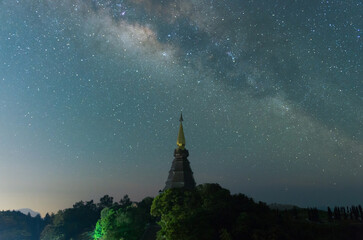 Wall Mural - the milky way galaxy over a sacred temple at doi inthanon national park, chiang mai, thailand. starr