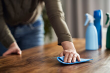Close up of caucasian woman cleaning table at home