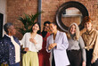 © Southworks - Portrait of cheerful multiethnic businesswomen laughing and smiling in office with exposed brick wall interior