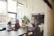 © Southworks - Portrait of senior white businesswoman discussing with multiethnic female colleagues in boardroom meeting
