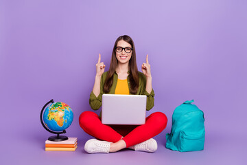 Poster - Portrait of attractive girl using laptop pointing up copy space doing homework isolated over violet purple color background